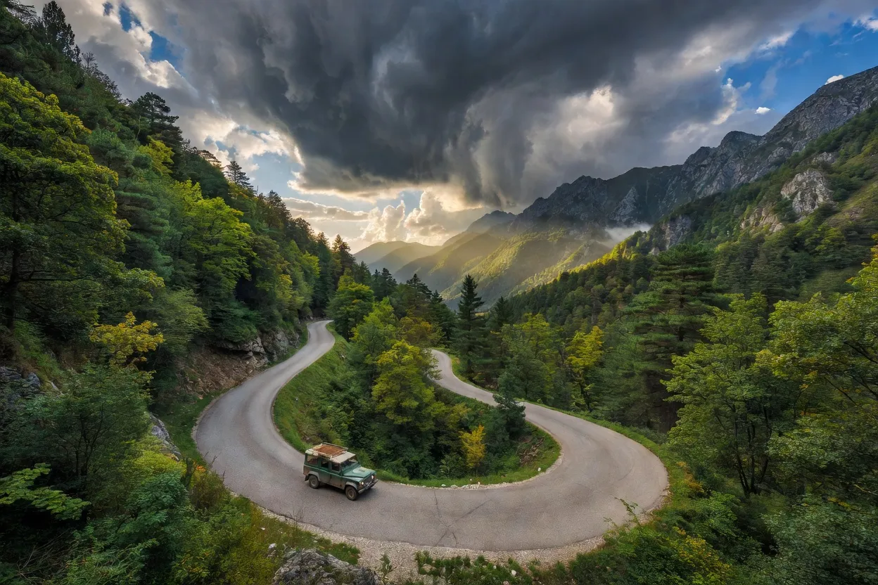 Route de montagne sinueuse dans un col forestier des Balkans avec ciel dramatique
